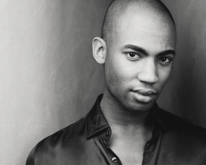 Dramatic black and white portrait photo of black male with a light background