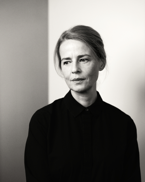 Low key black and white portrait photograph with light background of women in dark clothing, looking off camera.  